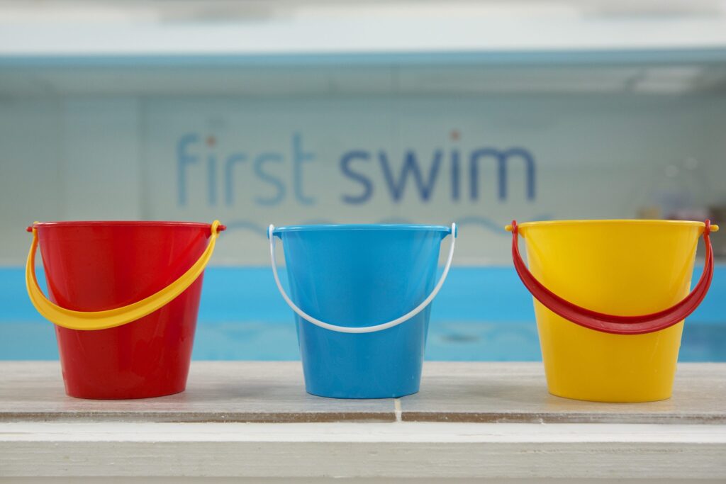 Colourful lesson buckets beside the pool