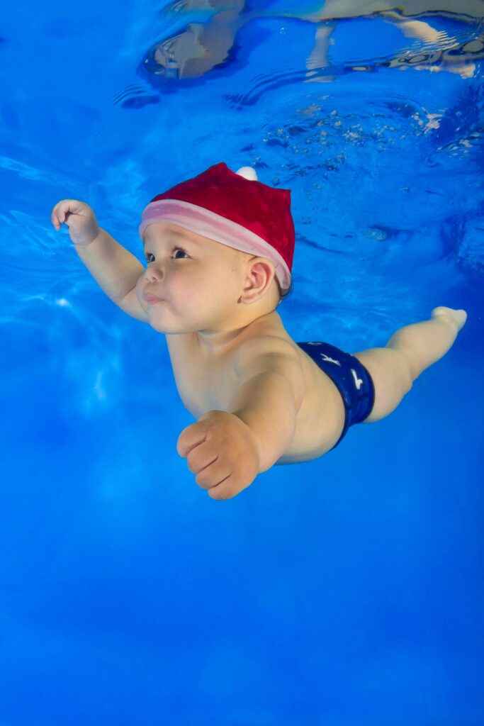 A baby wearing a festive hat during an underwater photoshoot